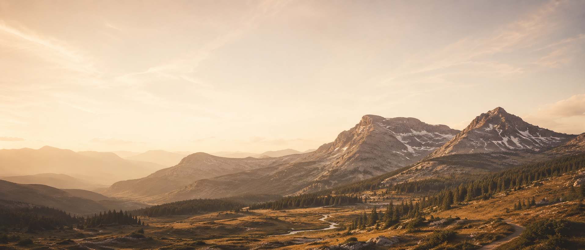 Golden-hour mountain landscape across Utah's Wasatch Back ridgeline with alpine meadows and winding trail